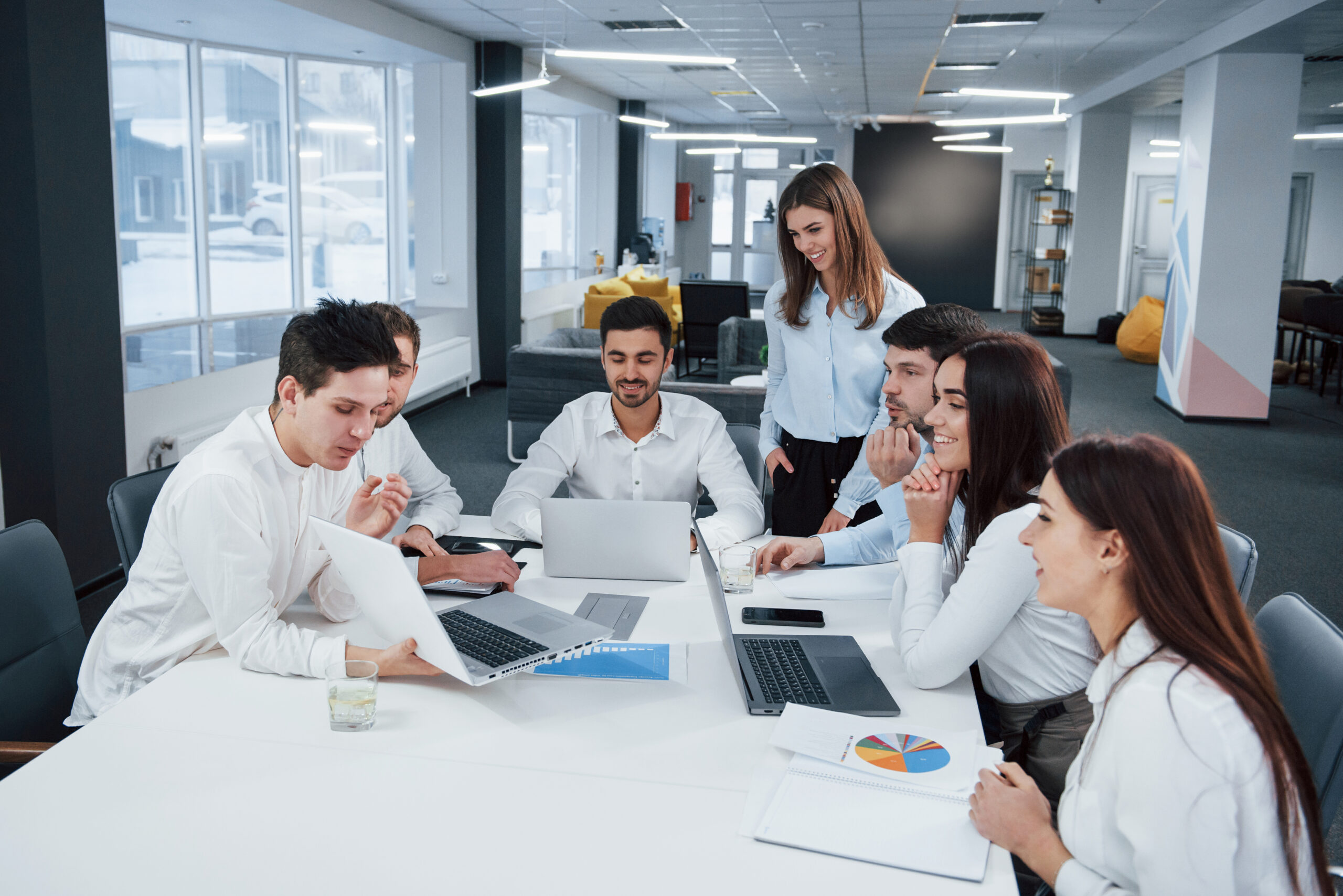 Showing good results. Group of young freelancers in the office have conversation and smiling.